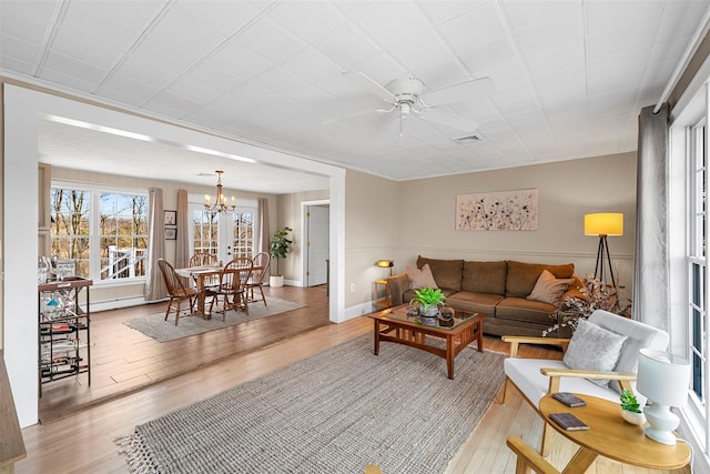 living room featuring ceiling fan with notable chandelier and light hardwood / wood-style flooring