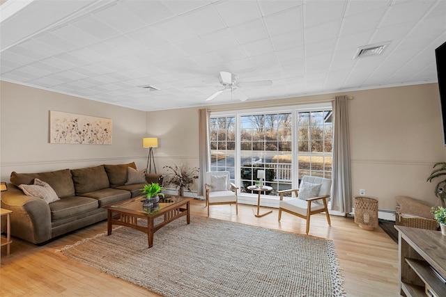 living room featuring wood-type flooring, ceiling fan, and ornamental molding