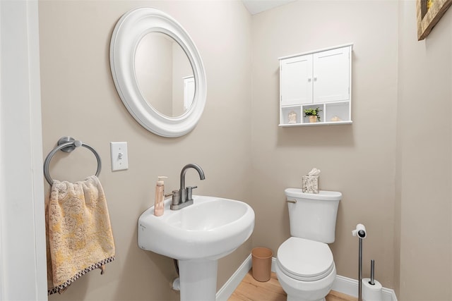 bathroom with hardwood / wood-style flooring, sink, and toilet