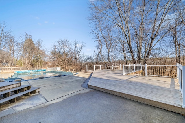 wooden terrace with a patio and a covered pool