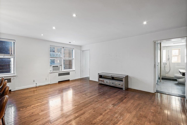 65-35 Yellowstone Blvd Unit 2H, Forest Hills, NY 11375 - unfurnished living room featuring radiator, hardwood / wood-style flooring, healthy amount of natural light, and recessed lighting
