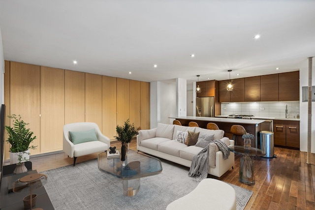 living room featuring dark wood-type flooring and sink