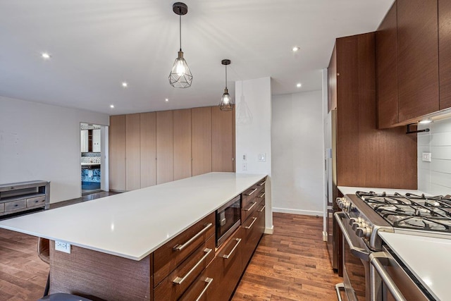 kitchen with tasteful backsplash, dark hardwood / wood-style flooring, stainless steel appliances, and decorative light fixtures