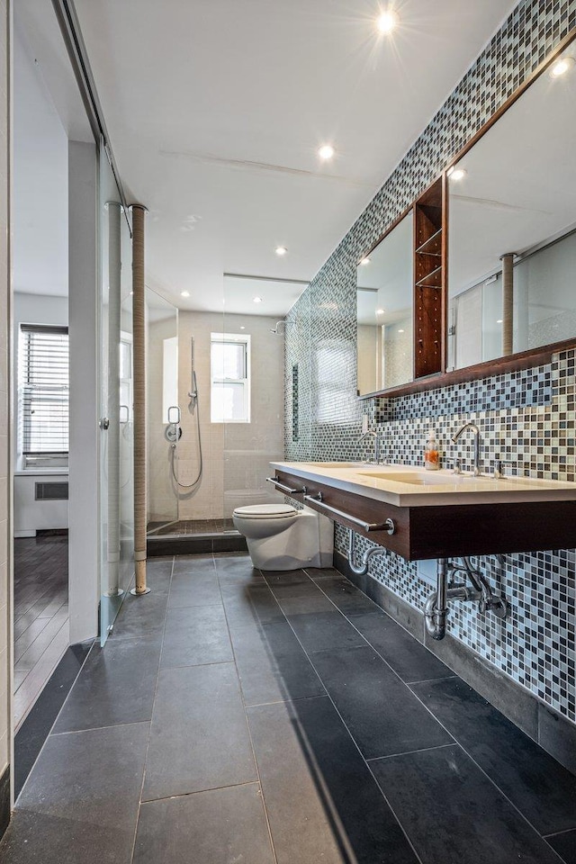 bathroom with tasteful backsplash, tile patterned floors, a shower, toilet, and tile walls