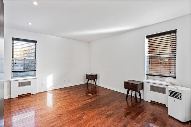 living room with radiator heating unit and dark wood-type flooring