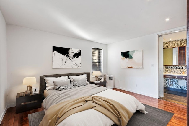 bedroom featuring ensuite bath and wood-type flooring