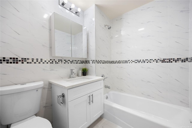 full bathroom with tiled shower / bath, vanity, toilet, and tile walls