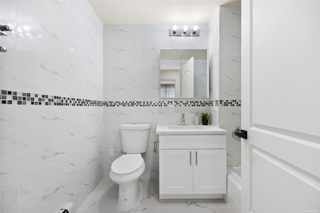 bathroom with vanity, toilet, and tile walls