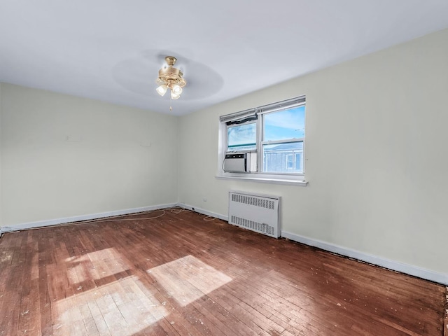 unfurnished room featuring radiator heating unit, ceiling fan, and wood-type flooring