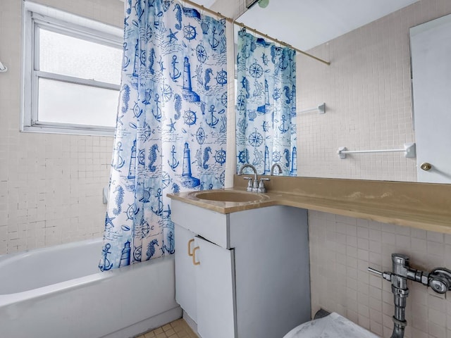 bathroom with shower / tub combo with curtain, vanity, and tile walls