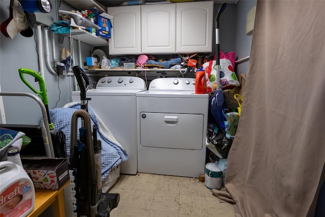 clothes washing area featuring separate washer and dryer and cabinets