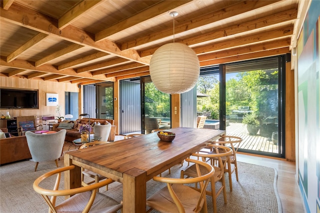 dining room with light hardwood / wood-style flooring, beamed ceiling, and wooden ceiling