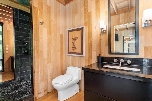 bathroom with wooden walls, hardwood / wood-style floors, vanity, and toilet