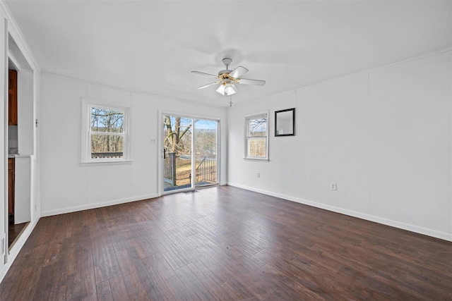 empty room with ceiling fan, dark wood-type flooring, and ornamental molding