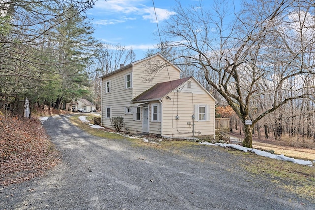 view of home's exterior with a chimney and aphalt driveway