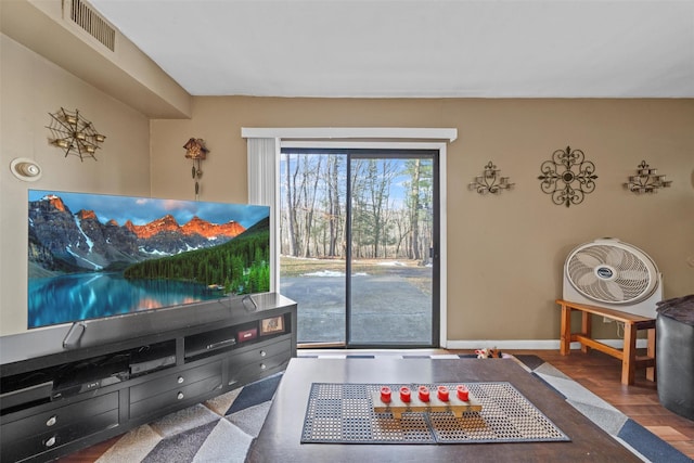 living room featuring visible vents, baseboards, and wood finished floors