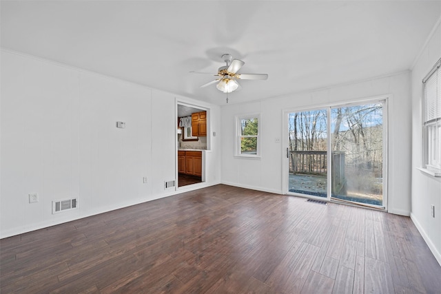 unfurnished living room with dark wood-style floors, ceiling fan, and visible vents