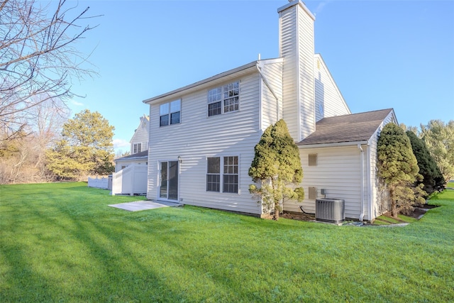 rear view of house with a yard and central AC