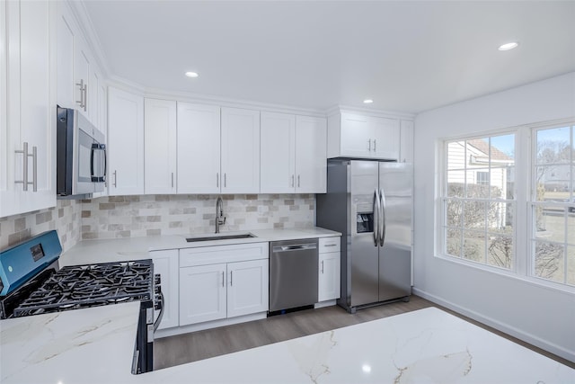 kitchen featuring light stone countertops, sink, white cabinets, and stainless steel appliances