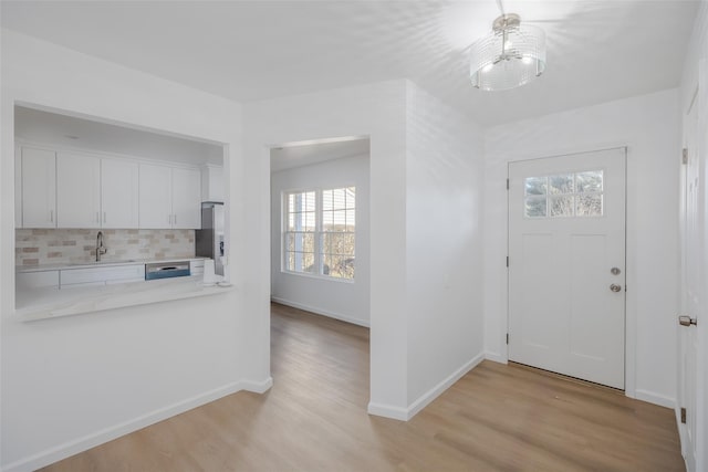 entrance foyer featuring sink and light hardwood / wood-style floors