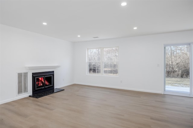 unfurnished living room featuring light hardwood / wood-style floors and plenty of natural light