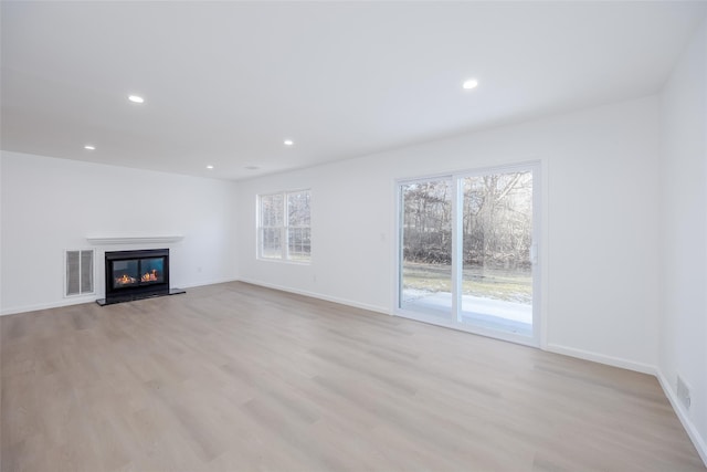 unfurnished living room with a healthy amount of sunlight and light wood-type flooring