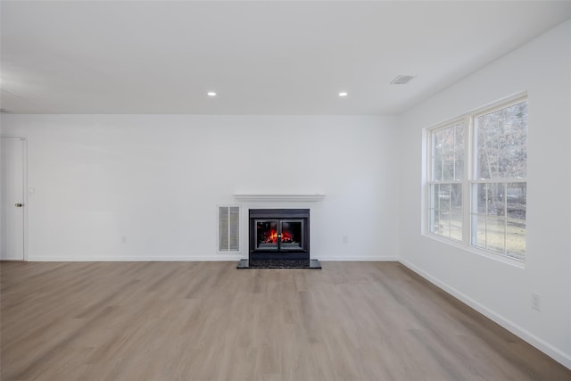 unfurnished living room featuring light hardwood / wood-style flooring and a healthy amount of sunlight