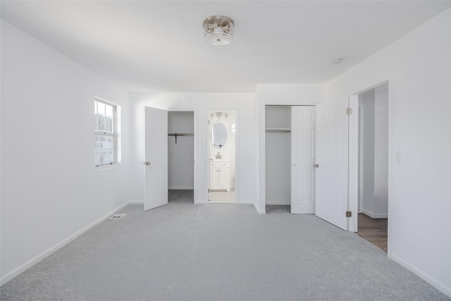 unfurnished bedroom featuring carpet floors and connected bathroom