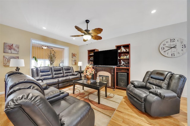 living room with light hardwood / wood-style flooring and ceiling fan