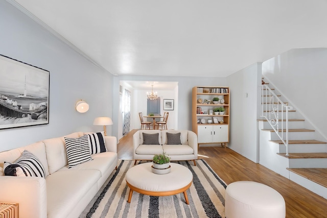 living room featuring a chandelier, hardwood / wood-style floors, and crown molding