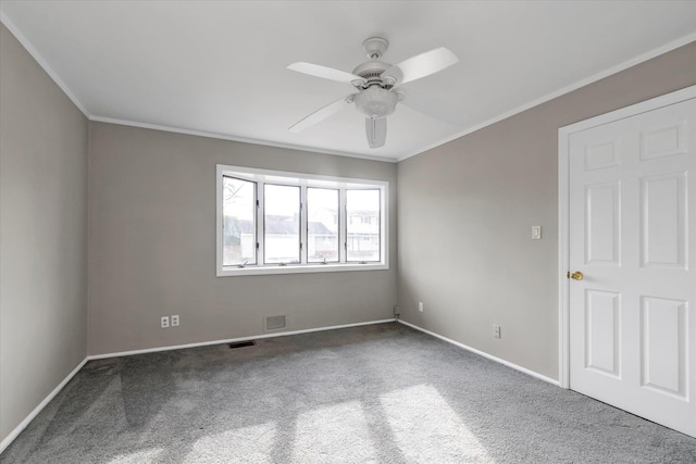 spare room featuring ceiling fan, carpet floors, and crown molding