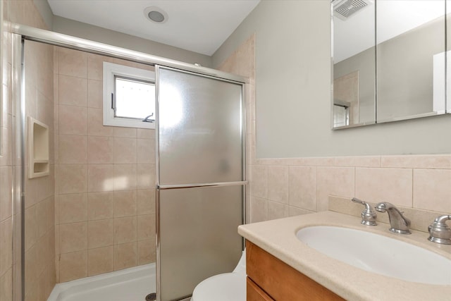 bathroom with a shower with door, vanity, and toilet