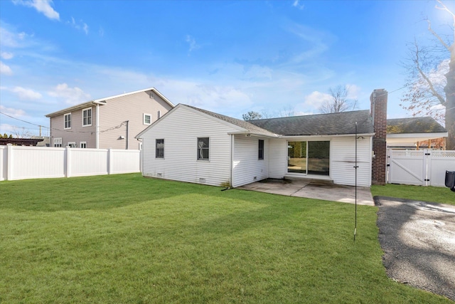 back of property with a lawn and a patio