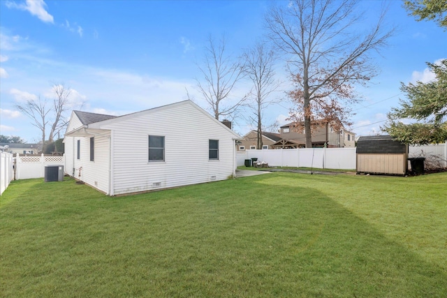 exterior space with central AC unit, a storage unit, and a yard