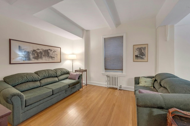 living room featuring hardwood / wood-style floors, radiator, and beam ceiling