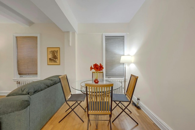 dining area with wood-type flooring and radiator heating unit