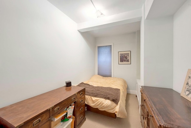 bedroom with light colored carpet and track lighting