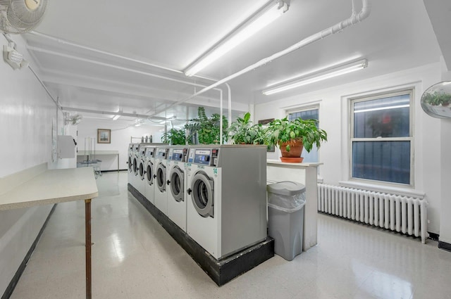 clothes washing area with radiator heating unit and washer and clothes dryer