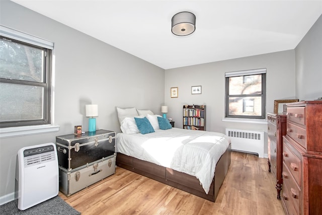 bedroom featuring light wood-type flooring and radiator