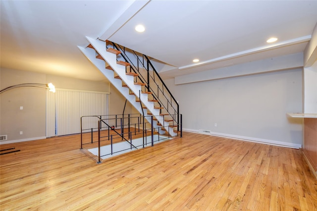 living room featuring beam ceiling and light wood-type flooring