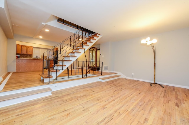 interior space featuring light wood-type flooring and an inviting chandelier