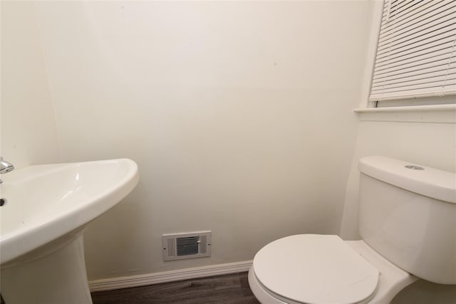 bathroom featuring hardwood / wood-style flooring and toilet