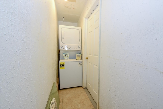 washroom with light tile patterned floors and stacked washer and dryer