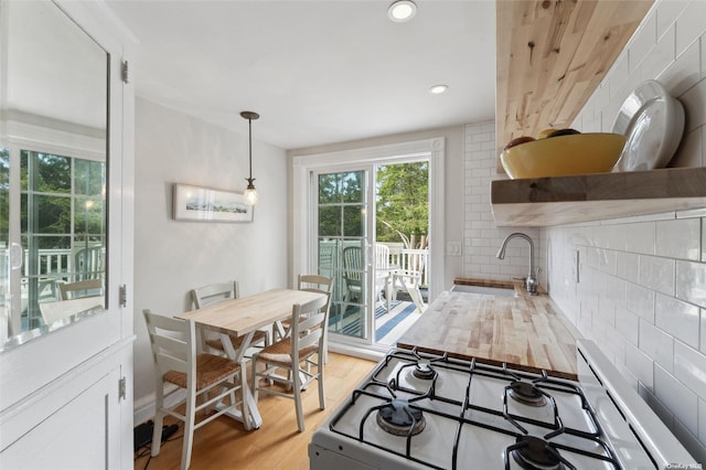 kitchen featuring light wood-style flooring, a sink, white gas range oven, recessed lighting, and light countertops