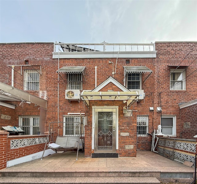 view of front of house featuring ac unit and brick siding