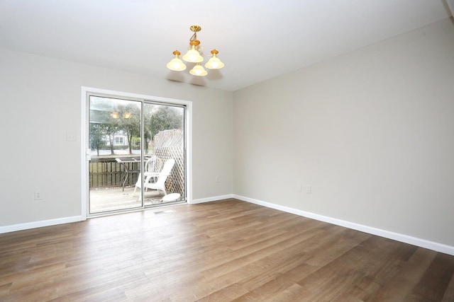 unfurnished dining area with wood-type flooring and a notable chandelier