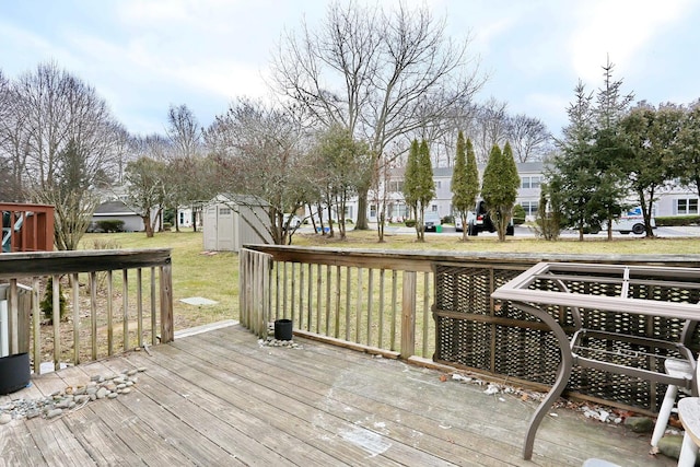 wooden deck with a storage unit and a yard