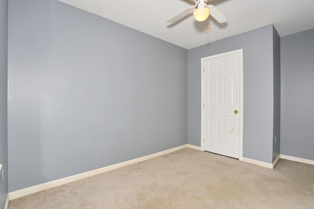 spare room with ceiling fan and light colored carpet