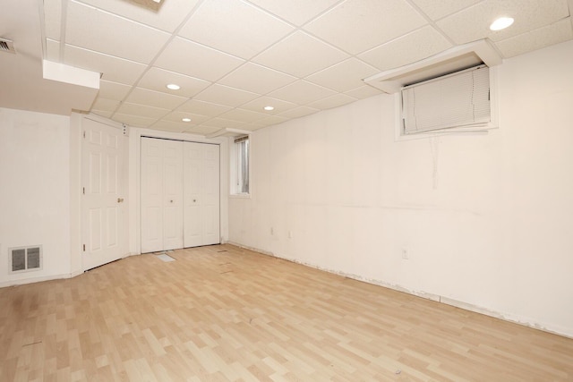 basement featuring hardwood / wood-style floors and a drop ceiling