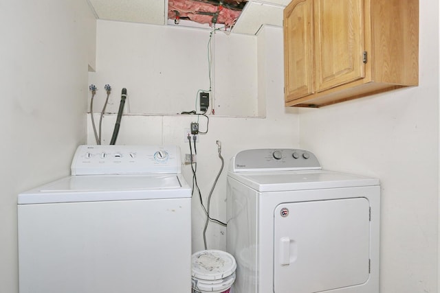 washroom featuring washing machine and clothes dryer and cabinets